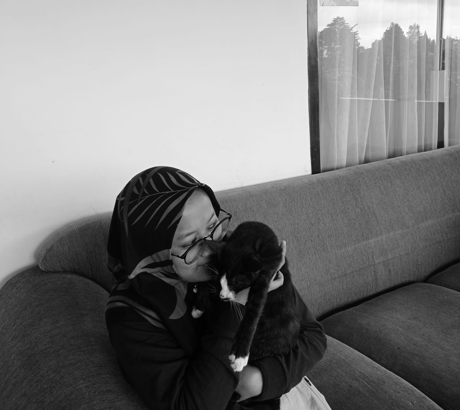 A person sitting at a chair with a straycat